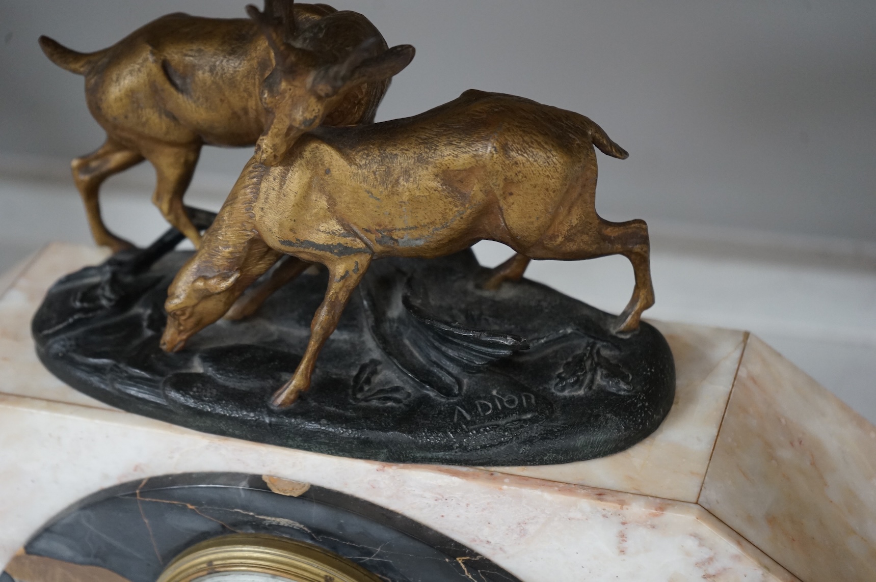 An Art Deco marble clock garniture and a French clock surmounted with two deer, with key, 44cm wide